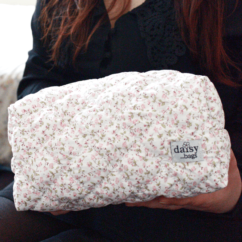 Young women holding a Daisy floral makeup bag