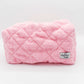 The Leela pink makeup bag on a grey background