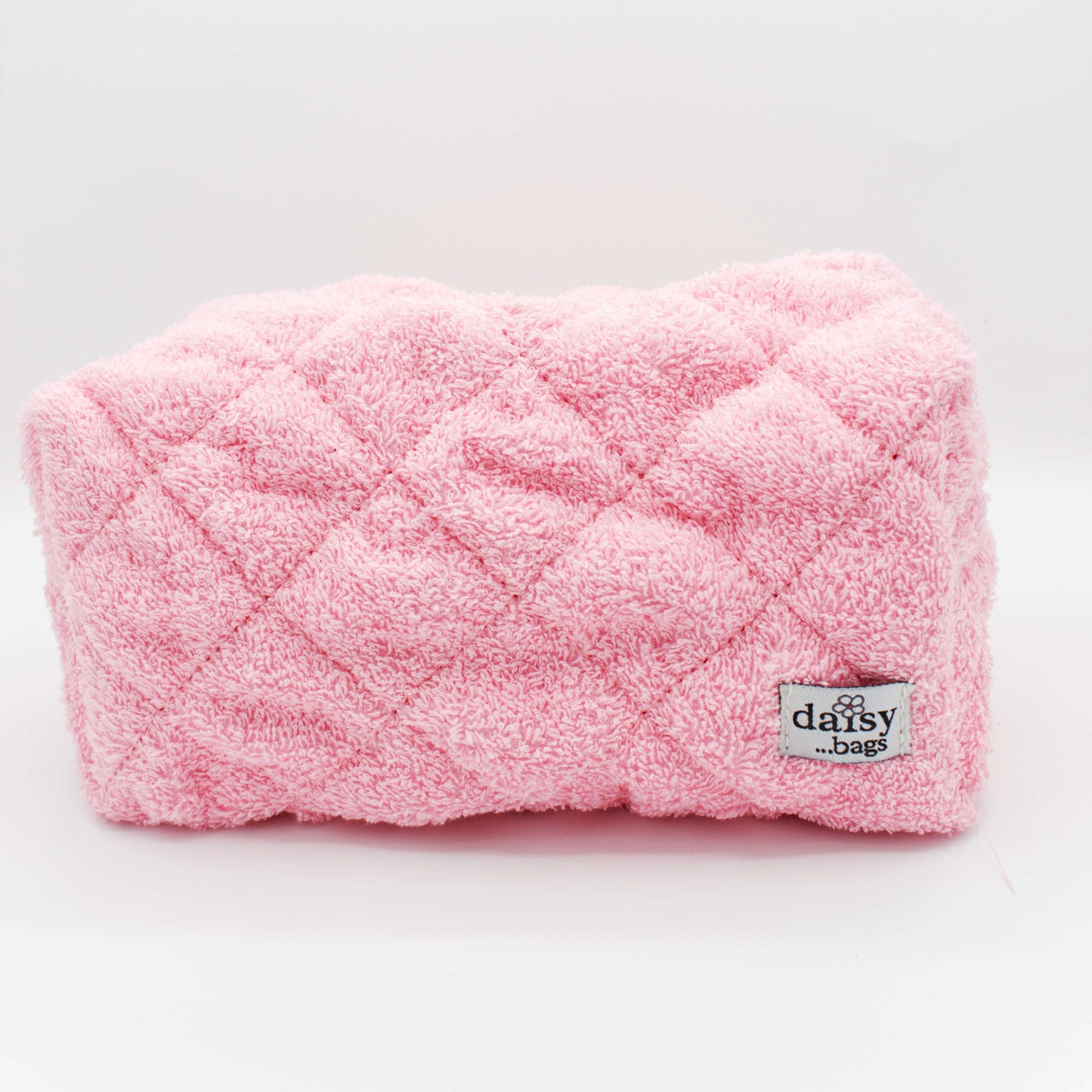 The Leela pink makeup bag on a grey background